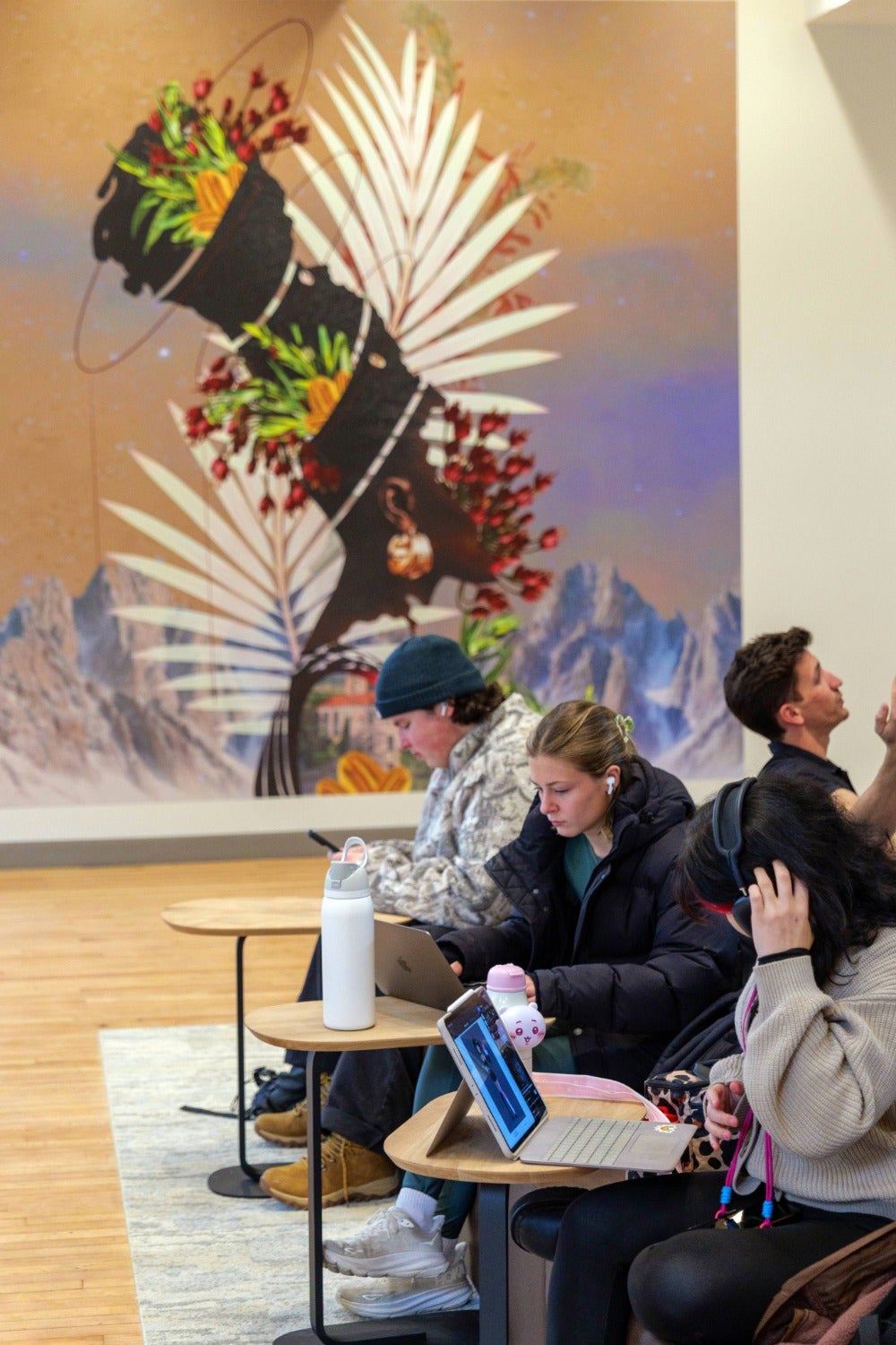 Students studying underneath artwork in new Hellems Building