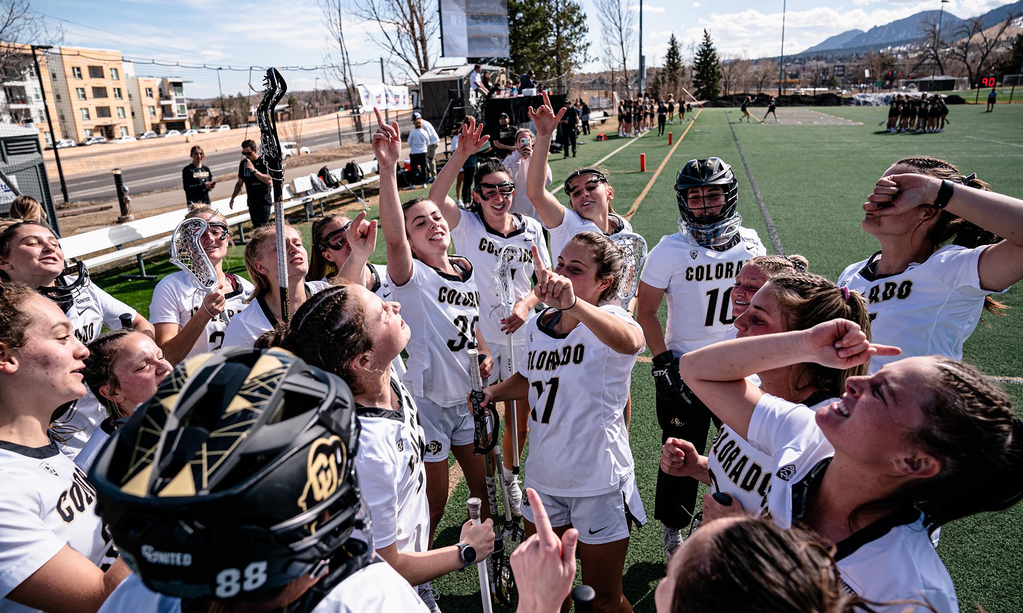 CU Boulder lacrosse players in a huddle