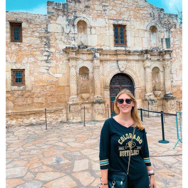 CU Boulder fan wearing a Buffs shirt in front of the Alamo