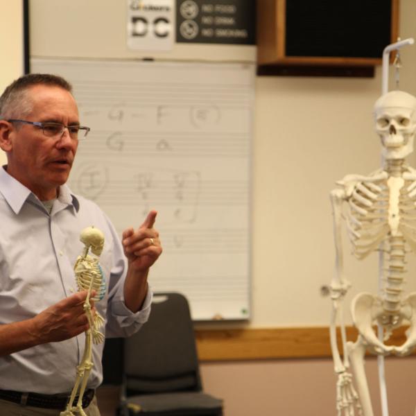 professor holding a skeleton
