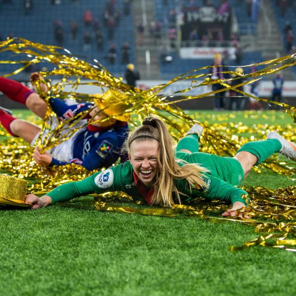 soccer goalie J.J. Tompkins celebrates on the soccer field with gold streamers around her