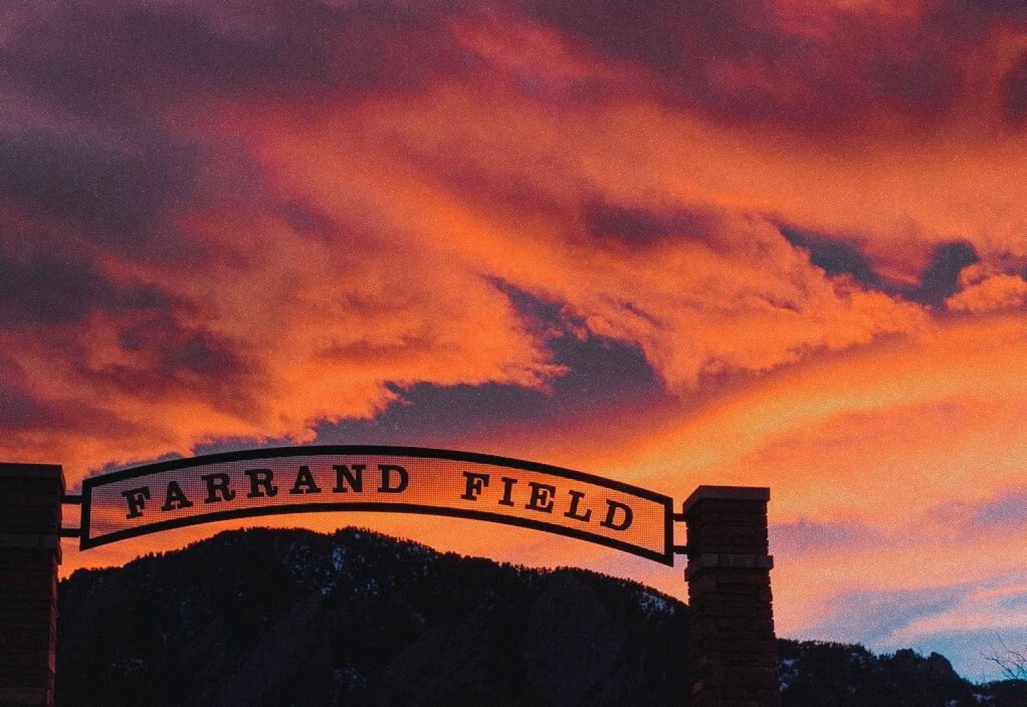 The sun sets over the arch of the entryway into Farrand Field.