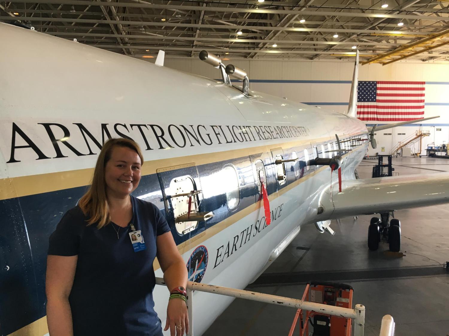 Jessica Gilman stands next to a plane that reads "Armstrong Flight Research Center"