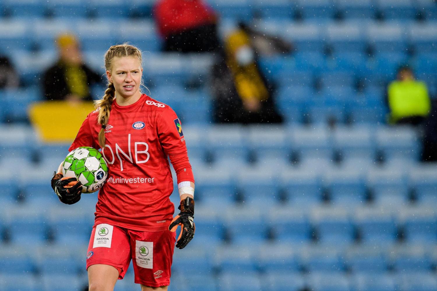 soccer goalie J.J. Tompkins holds a soccer ball while walking across the field