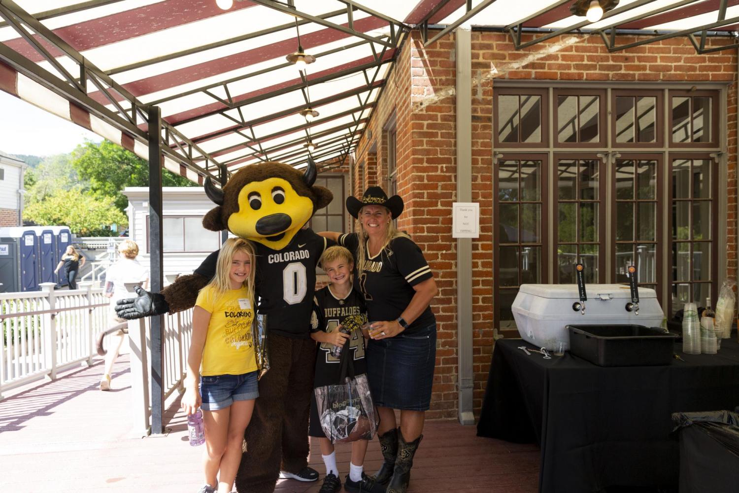 Chip with two kids and a woman at a tailgate party