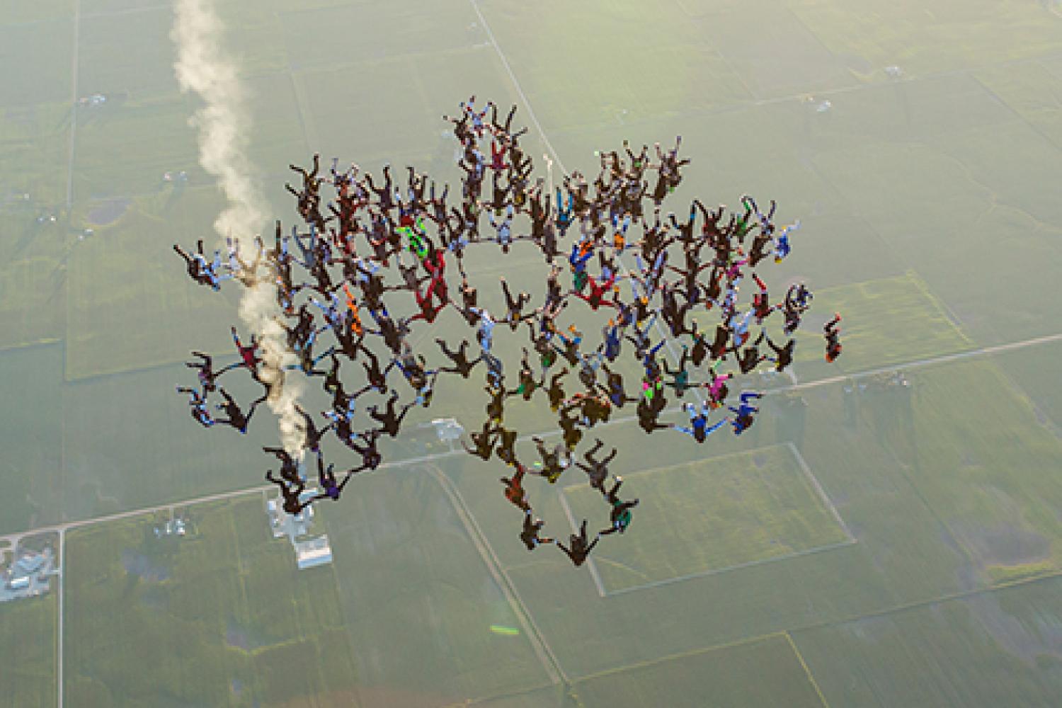 Photo of skydivers falling from the sky holding hands
