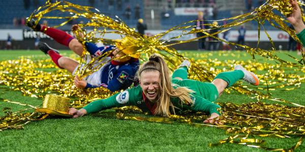 soccer goalie J.J. Tompkins celebrates on the soccer field with gold streamers around her