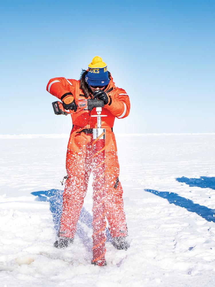 man drilling into the ice