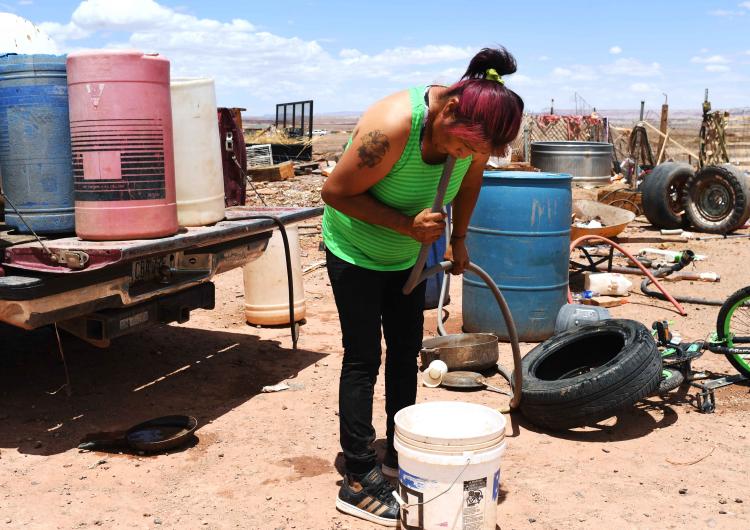 A navajo woman pumps water for use