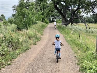 A child biking on a dirt path