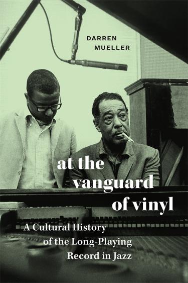 The cover features two men sitting in front of musical equipment. The cover is in black and white.