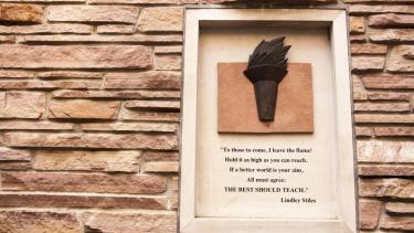 Quote and torch on campus