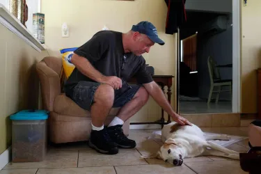 Old man petting his dog