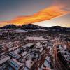A vibrant orange and yellow sunset over the snow covered CU Boulder campus.