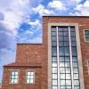 large window of the Imig Music Building against a blue sky