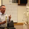 professor holding a skeleton
