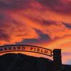The sun sets over the arch of the entryway into Farrand Field.
