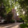 Sunlight peeks through the trees surrounding Macky Auditorium