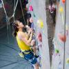 a cu boulder student scales a rock wall at the rec center