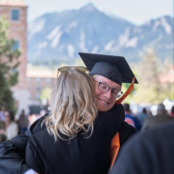 Graduating student hugging a guest