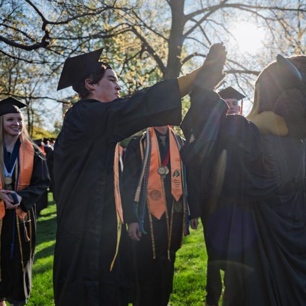 Graduating student high fives Ralphie