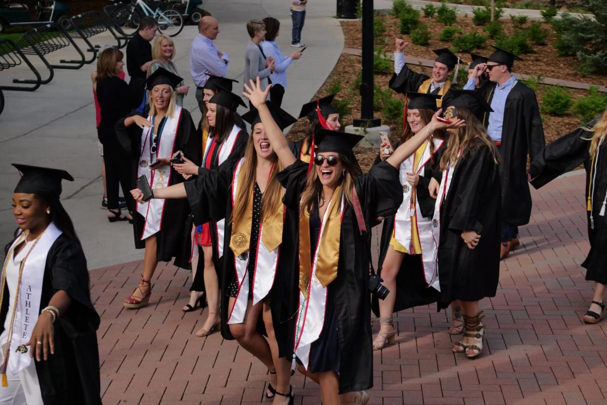Graduates enjoy the procession from the quad to CU Boulder's 2018 main commencement ceremony at Folsom Field