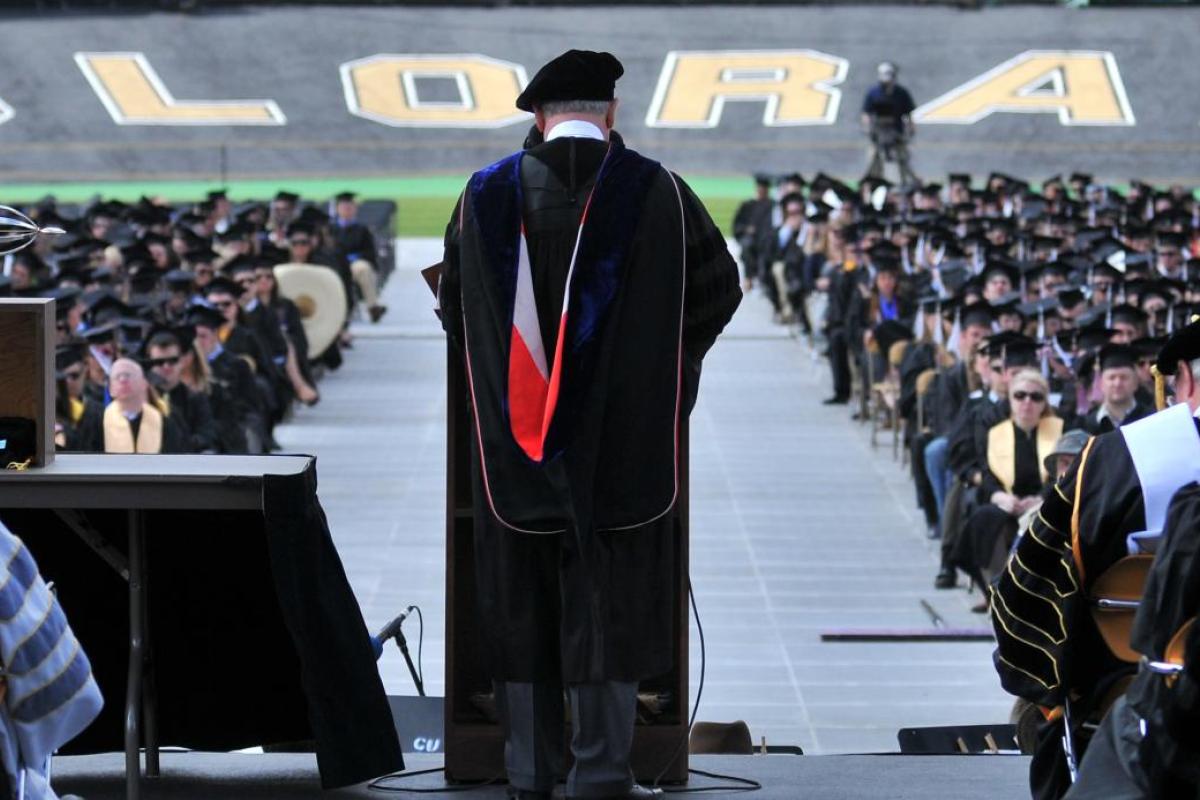 Chancellor Phil DiStefano addressing graduates in Folsom Field