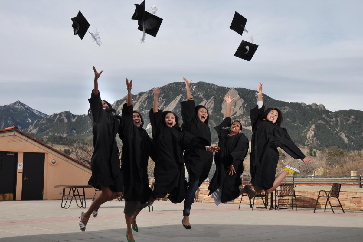 Graduates in their gowns tossing their caps