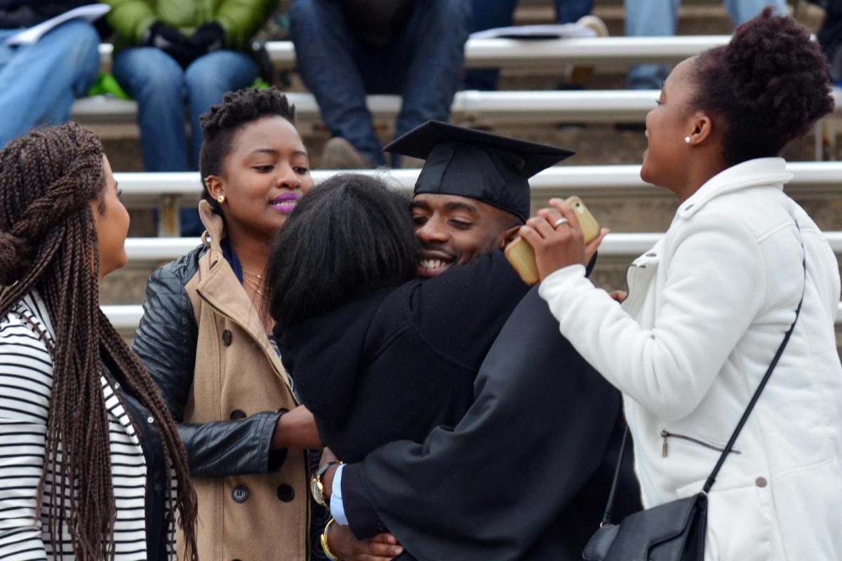 A graduate hugging friends and family.