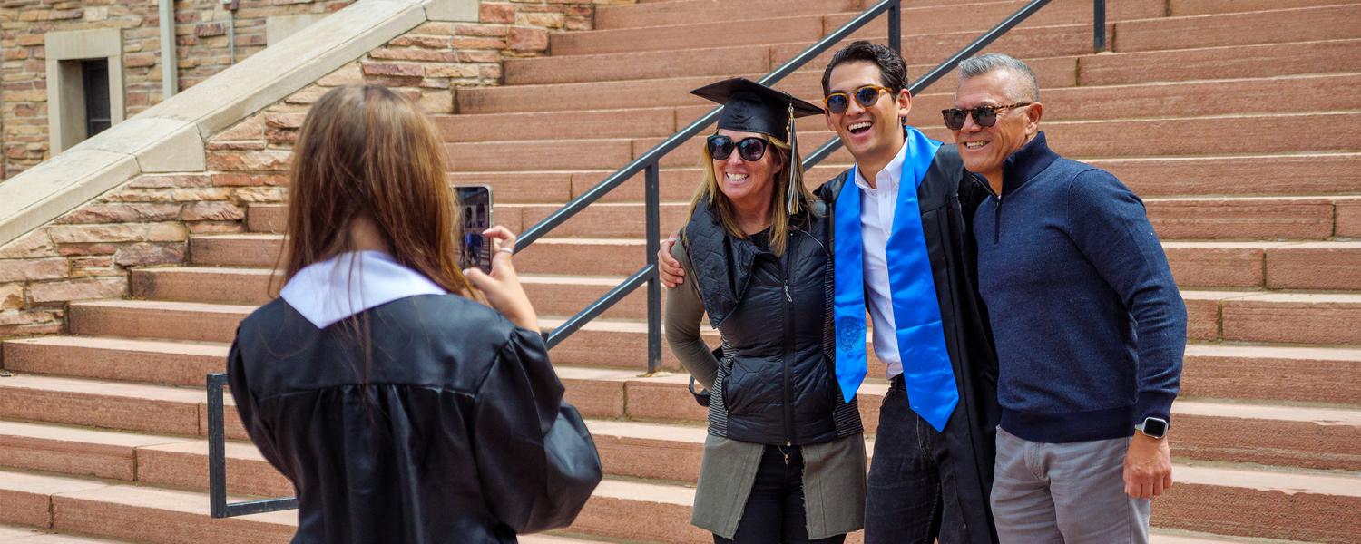 A graduate getting their photo taken with their family