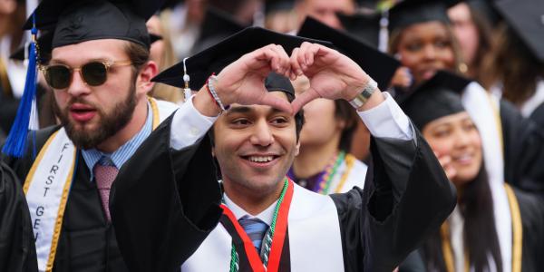 recent graduate making heart symbol with their hands