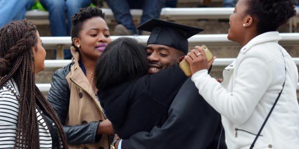 A graduate hugging friends and family.