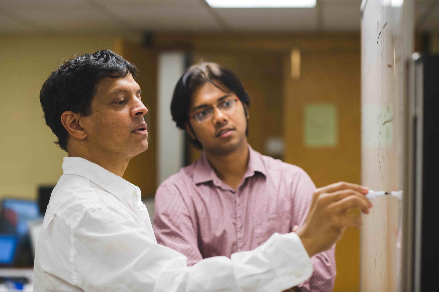 Prof. Mahesh Varanasi and student discuss research in the lab.