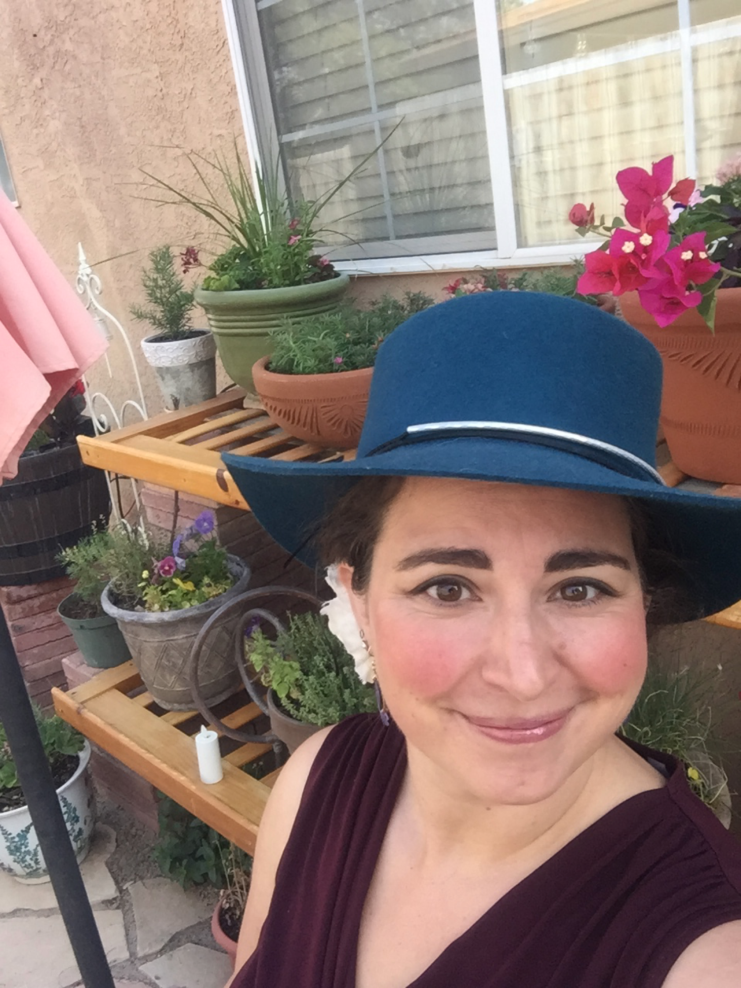 Jacquilyn Weeks in a hat with flowers behind her