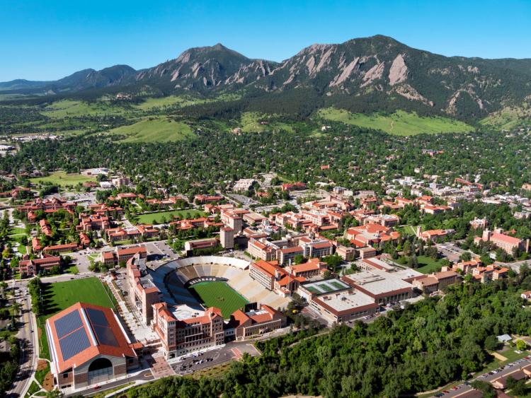 An aerial view of CU Boulder's main campus with the Flatirons beyond