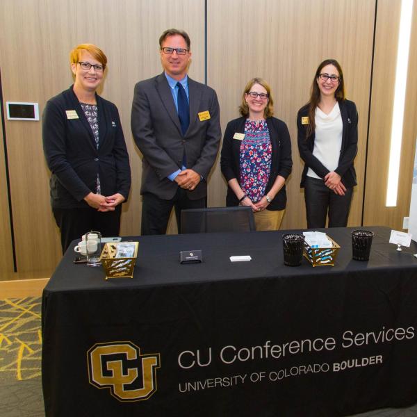 CUCS staff posting behind an adorned registration table