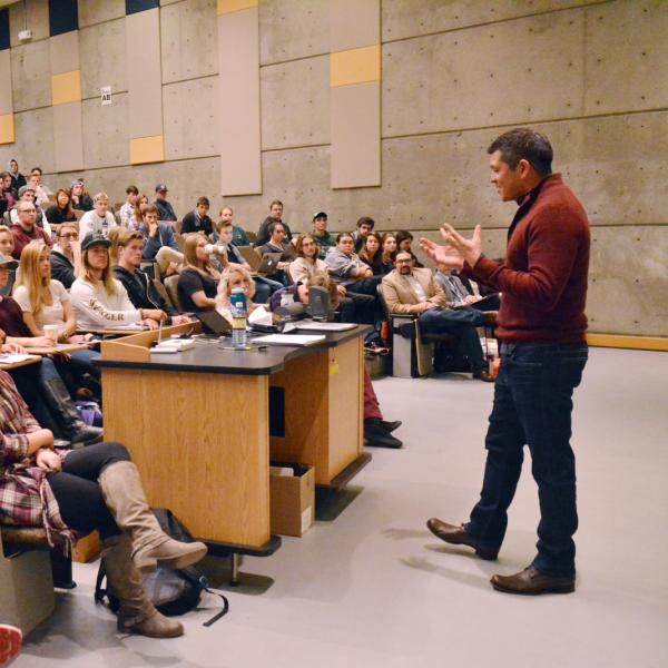 Stadium style classroom with professor speaking at front of room