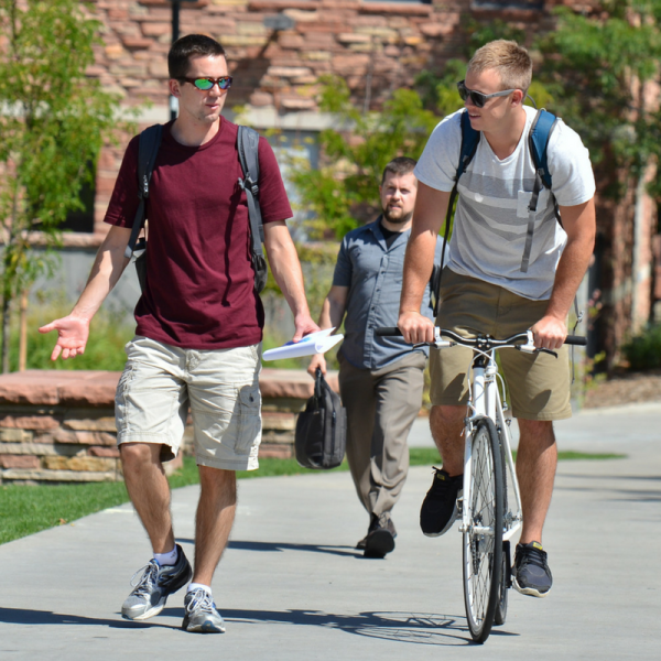 Two guys, one walking one cycling, talking