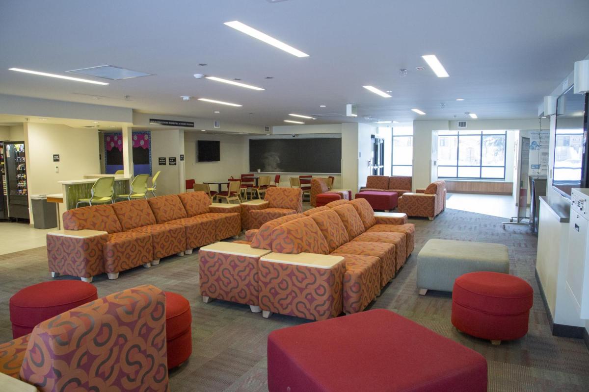 Kittredge West lounge area with multi-patterned modular furniture and foot stools, windows, carpeted floors