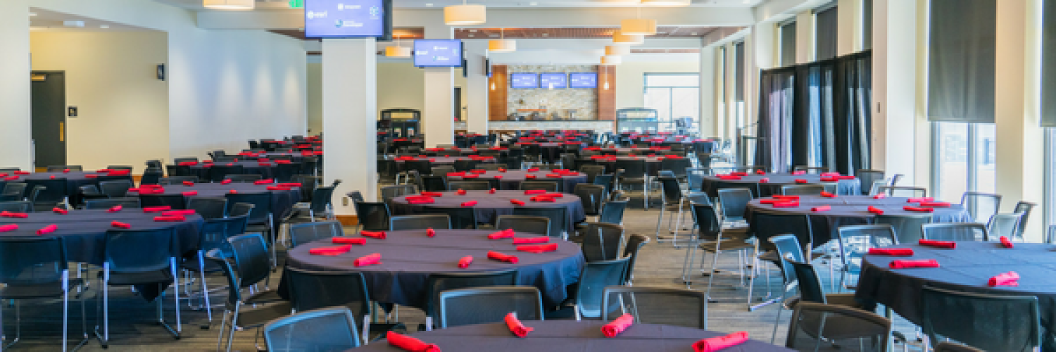 Conference room in Folsom Stadium with round tables, ready for a conference