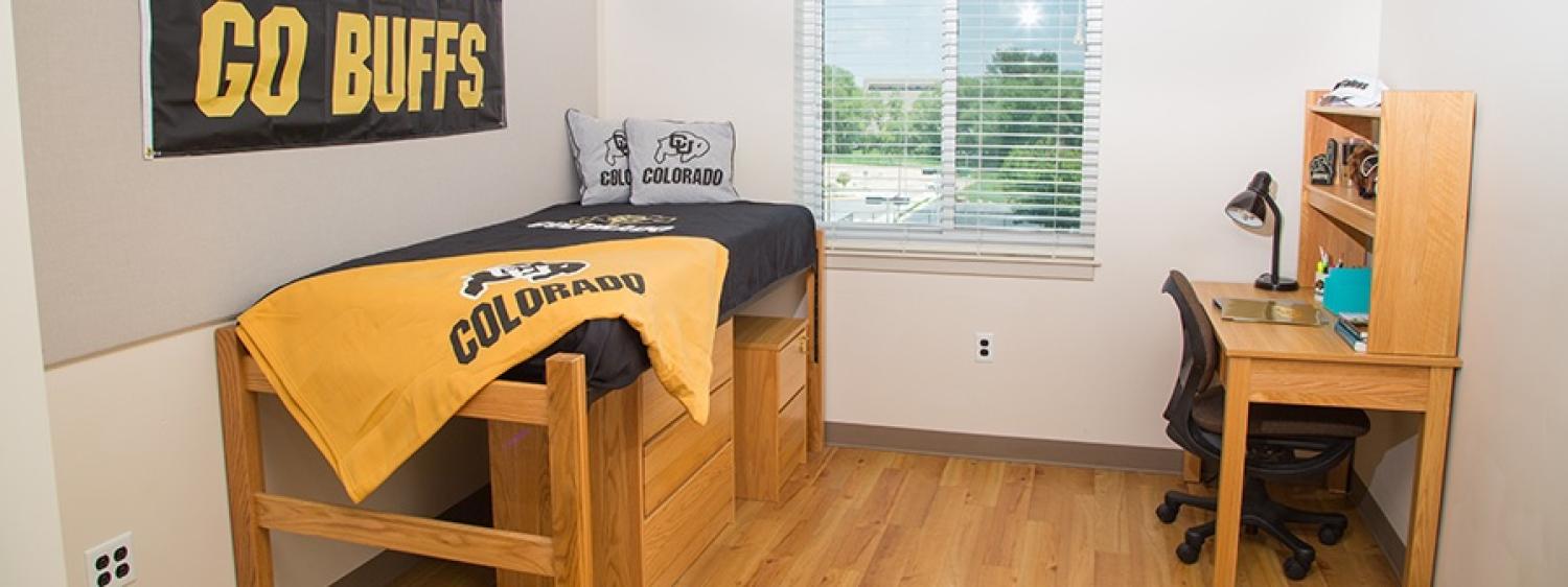 Single res hall room with bed, desk, window