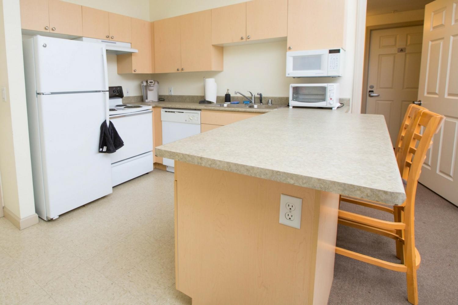 Kitchen with fridge/freezer, stove/oven, sink, dishwasher, microwave, breakfast bar, two bar stools