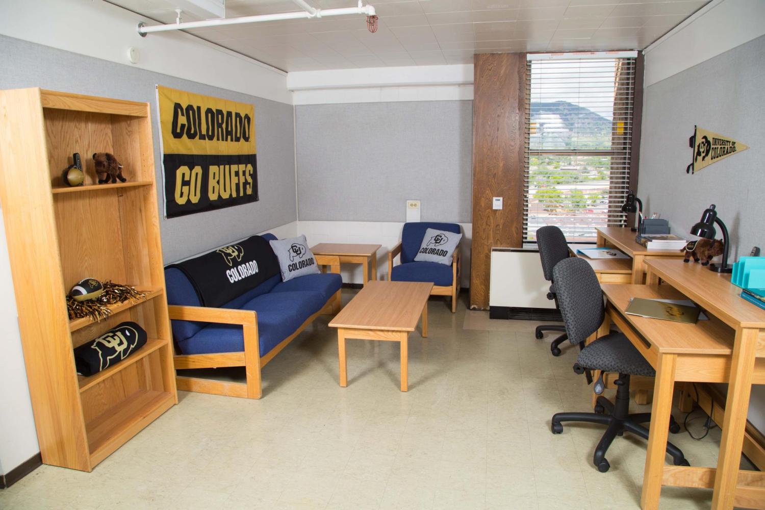 Stearns East apartment, living area with sofa, chair, side and coffee table, bookcase, and two desks