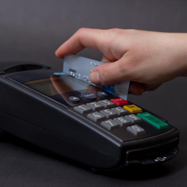 Hand swiping a credit card on a machine