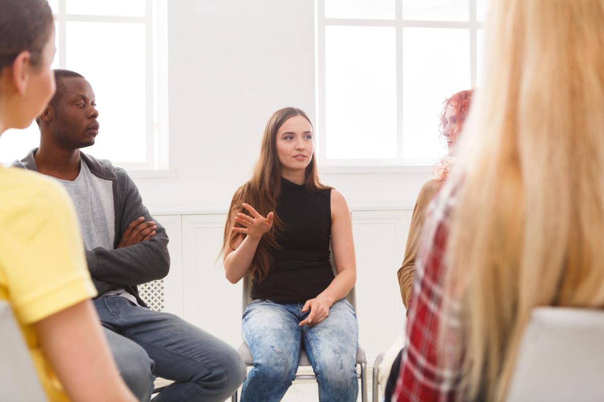 Photo of students sitting in a group therapy session.