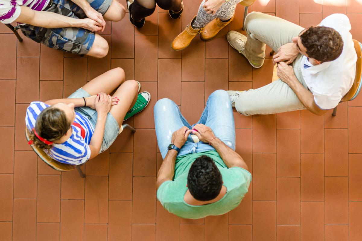 Overhead photo of students talking in a therapy group circle.