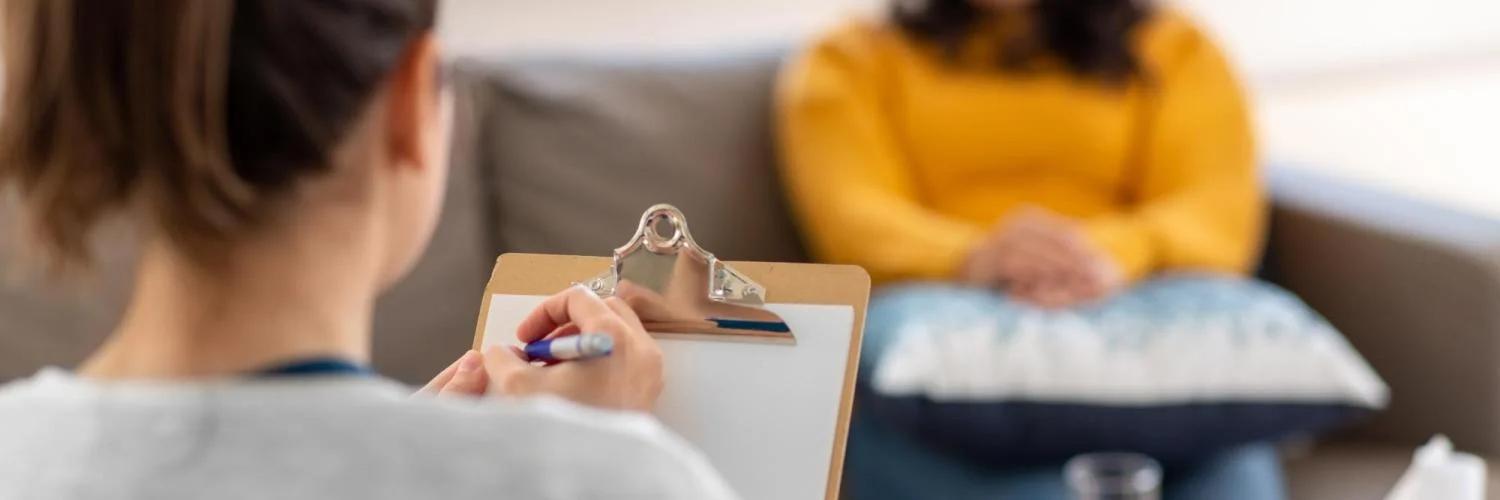 Photo of a counselor taking notes during an appointment.