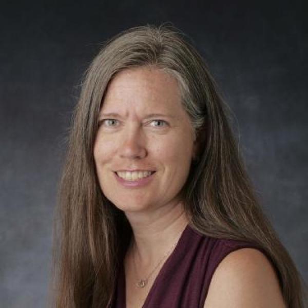Woman with dark hair wearing burgundy top