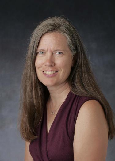 Woman with dark hair wearing burgundy top