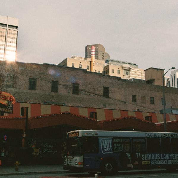 Photo of a Downtown view of buildings, restaurants, and a bus.